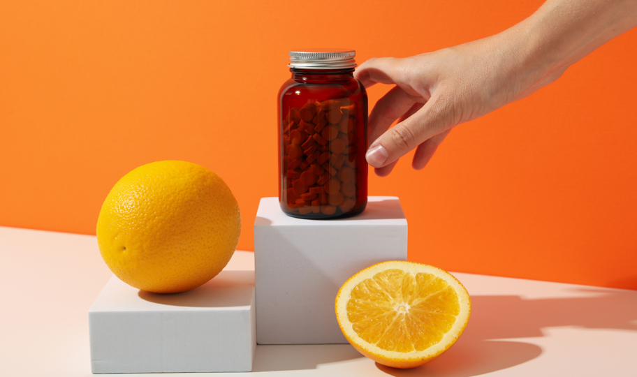 vitamin c u bočici u obliku tableta, naranče