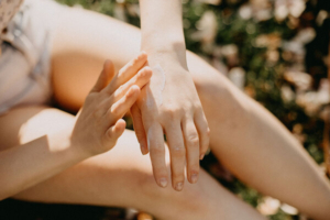 žena u kupaćem kostimu maže ruke zaštitnim faktorom