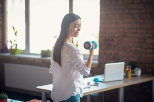 žena vježba s bučicama u uredu