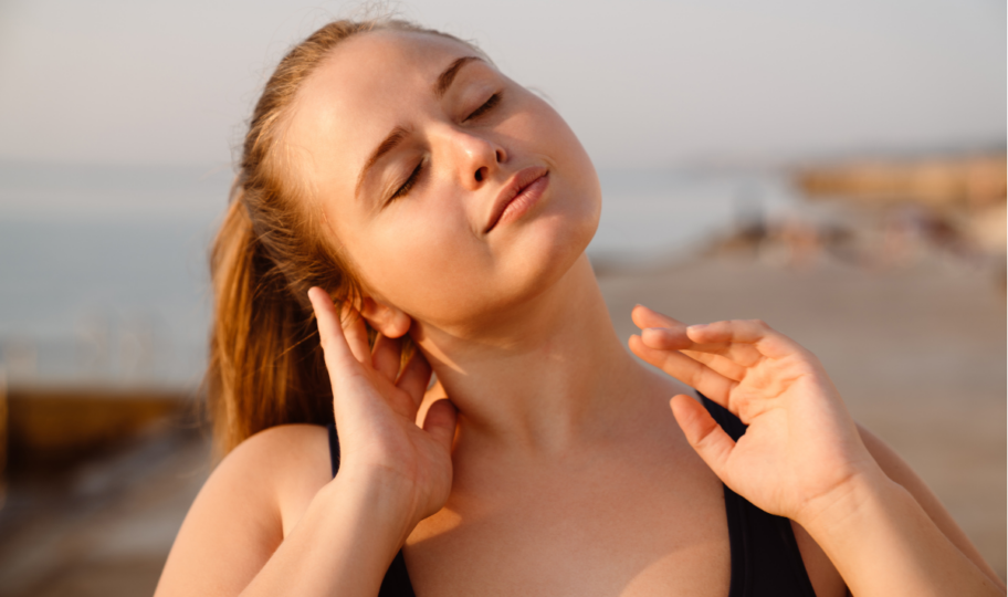 krupni kadar mlade žene na plaži koja pokušava odčepiti uši