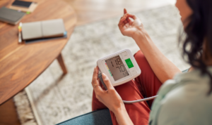 mlada žena si mjeri tlak u dnevnom boravku