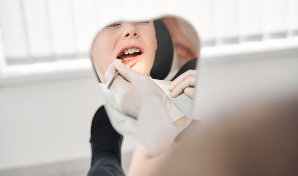 dječak s fiksnim aparatićem na pregledu kod ortodonta