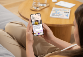 žena sjedi na kauču i gleda meddox an mobitelu