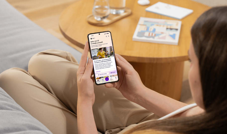 žena sjedi na kauču i gleda meddox an mobitelu