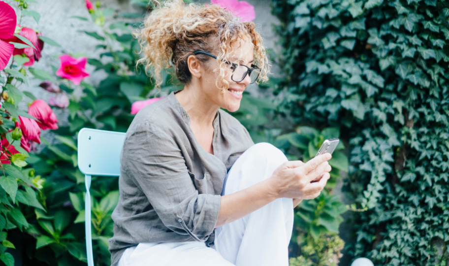 nasmijana žena koja gleda u mobitel