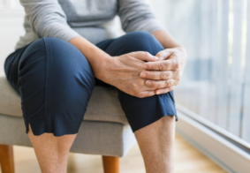 starija žena se drži za bolno koljeno krupni kadar