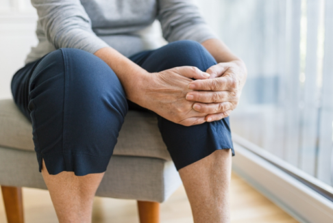 starija žena se drži za bolno koljeno krupni kadar