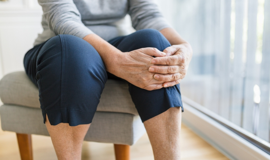 starija žena se drži za bolno koljeno krupni kadar