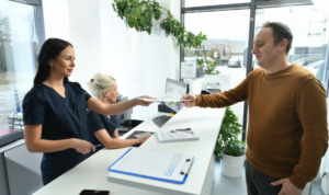 mškarac uzima nalaze od djelatnice za pultom