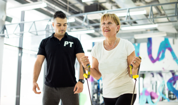 žena srednjih godina vježba s osobnim trenerom