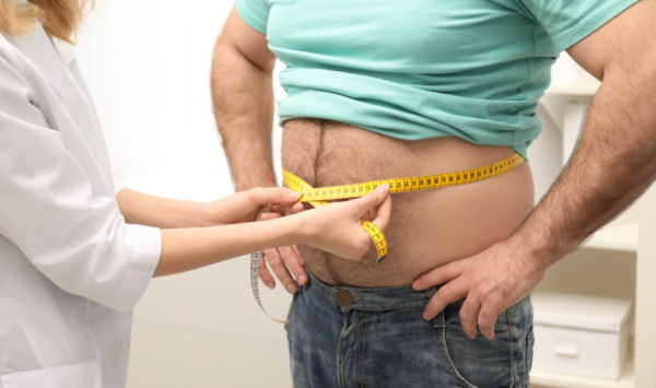 liječnica mjeri struk pretilom muškarcu