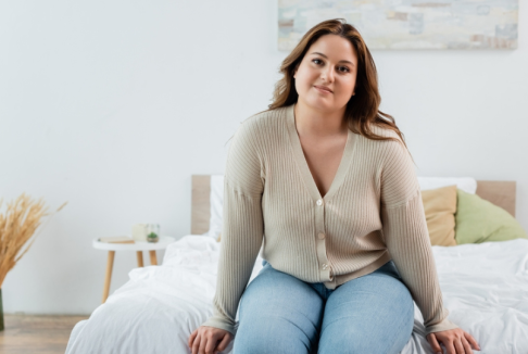 mlada debela žena sjedi na krevetu