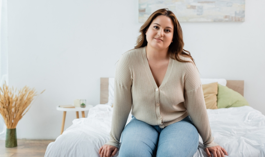 mlada debela žena sjedi na krevetu