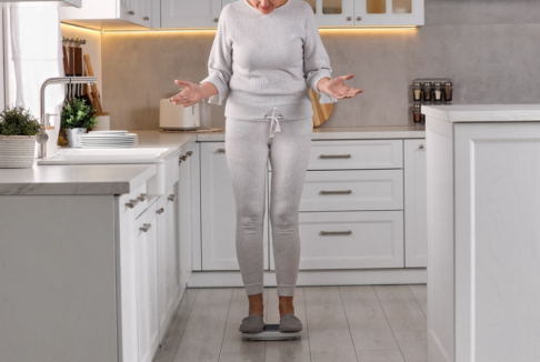 žena u menopauzi stoji na vagi i čudi se debljanju