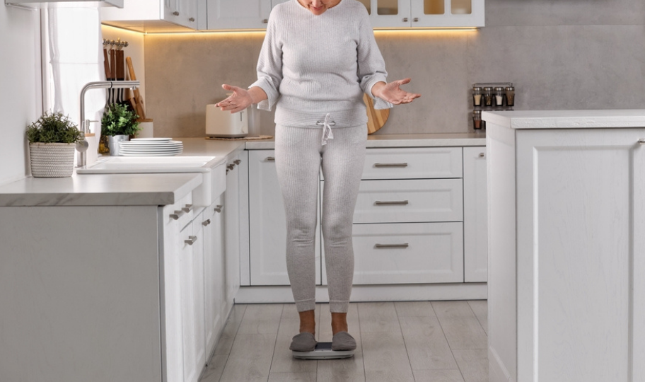 žena u menopauzi stoji na vagi i čudi se debljanju
