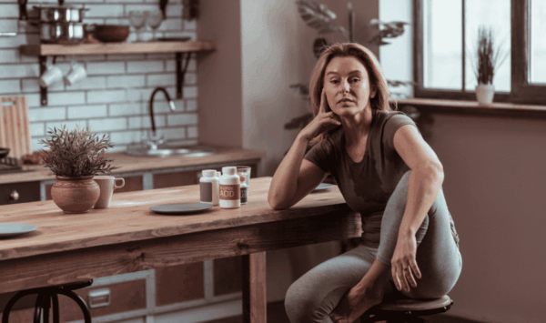 žena u perimenopauzi sjedi za otokomu kuhinji