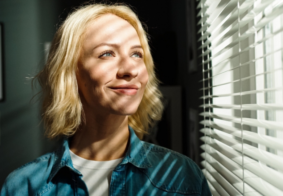 žena gleda u dnevno svjetlo kroz prozor